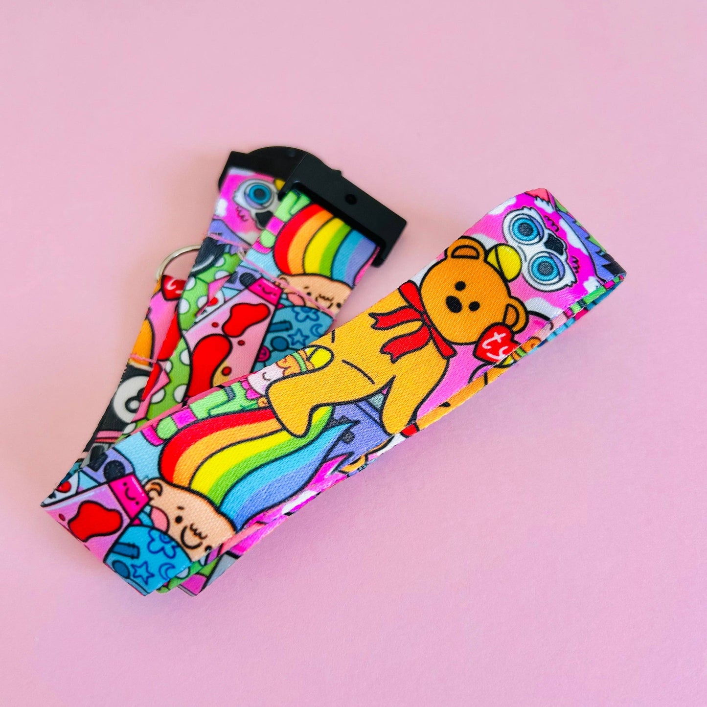 Colorful fabric strip with teddy bears and rainbows on a pink background