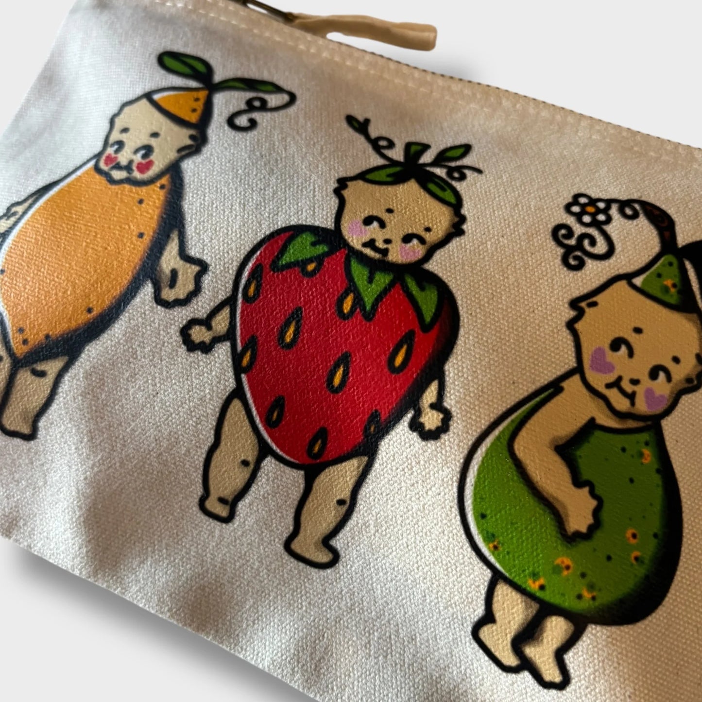 Pouch with cartoon characters in fruit costumes on a beige background
