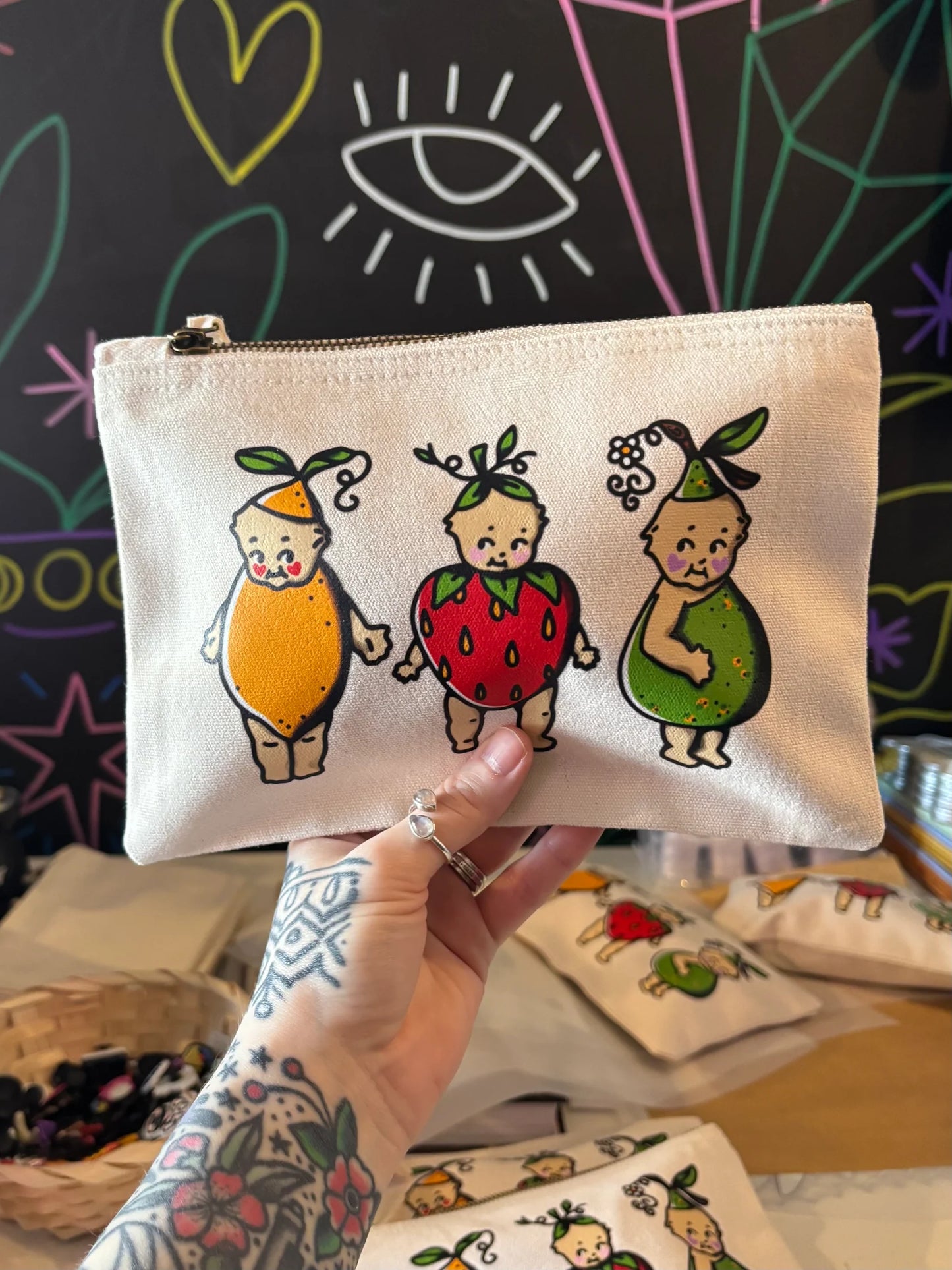 Hand holding a small pouch with cartoon characters on a colorful background