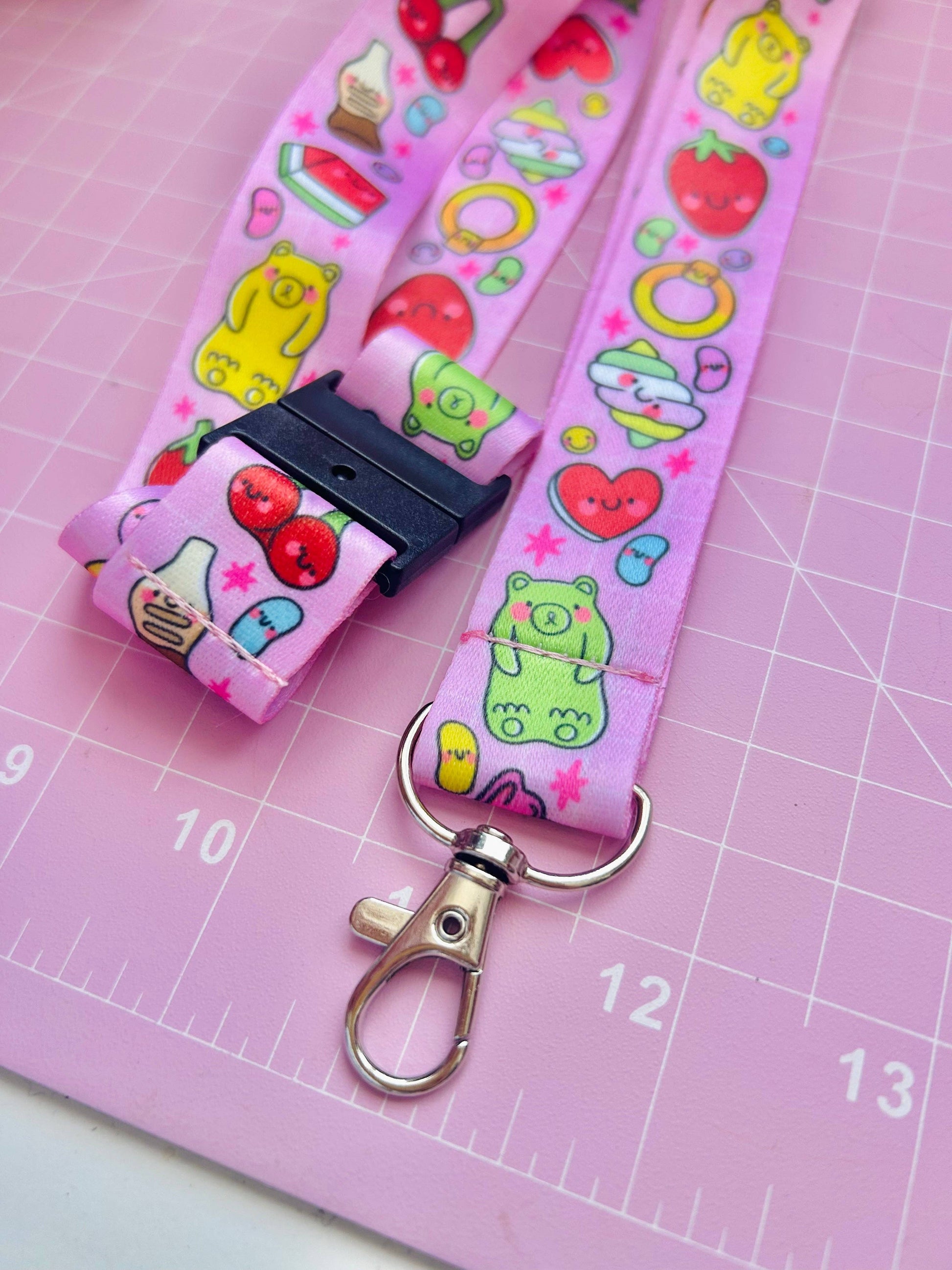 Pink lanyard with colorful cartoon designs on a pink cutting mat.