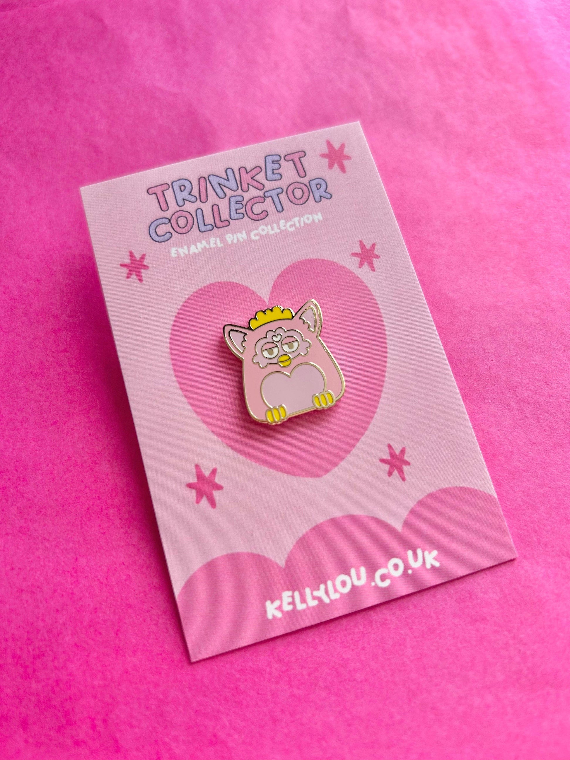 Pink card with a cartoon cat pin and 'Trinket Collector' text on a pink background
