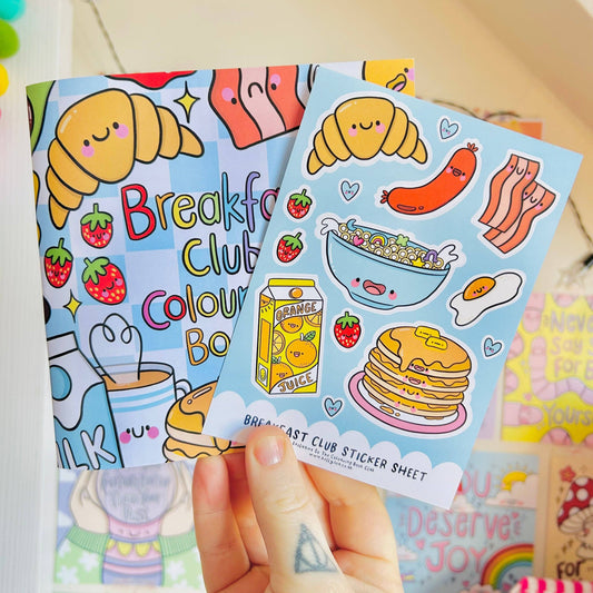 Colorful sticker sheets with breakfast-themed designs held by a hand.