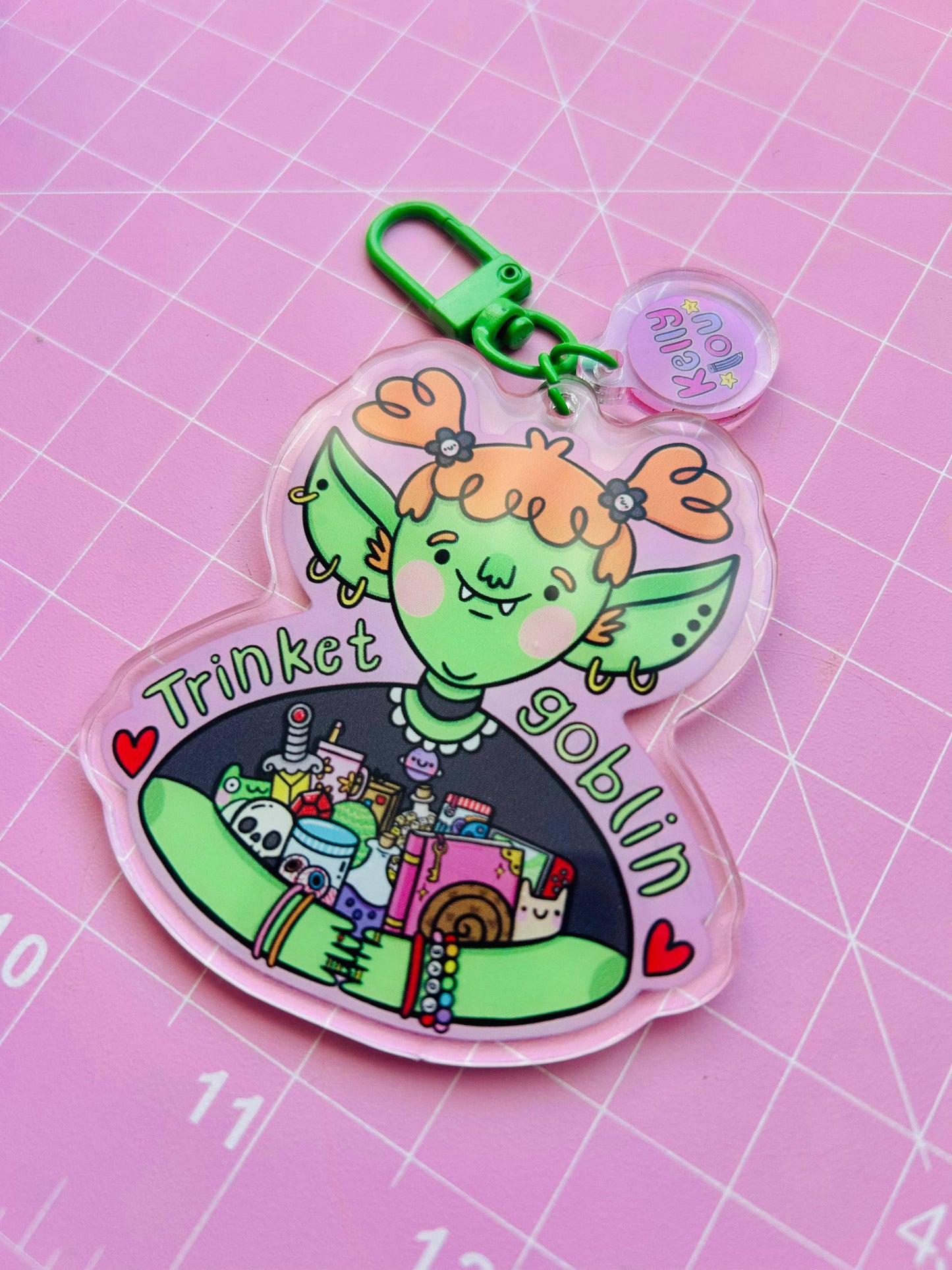 Colorful keychain with a cartoon character on a pink grid background