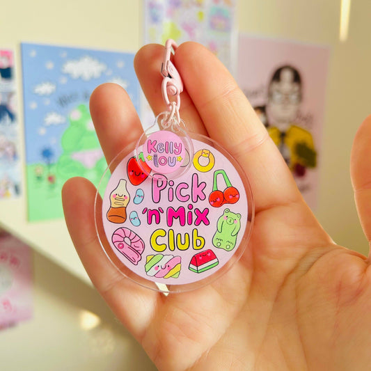 Hand holding a colorful keychain with 'Pick 'n' Mix Club' text and graphics.
