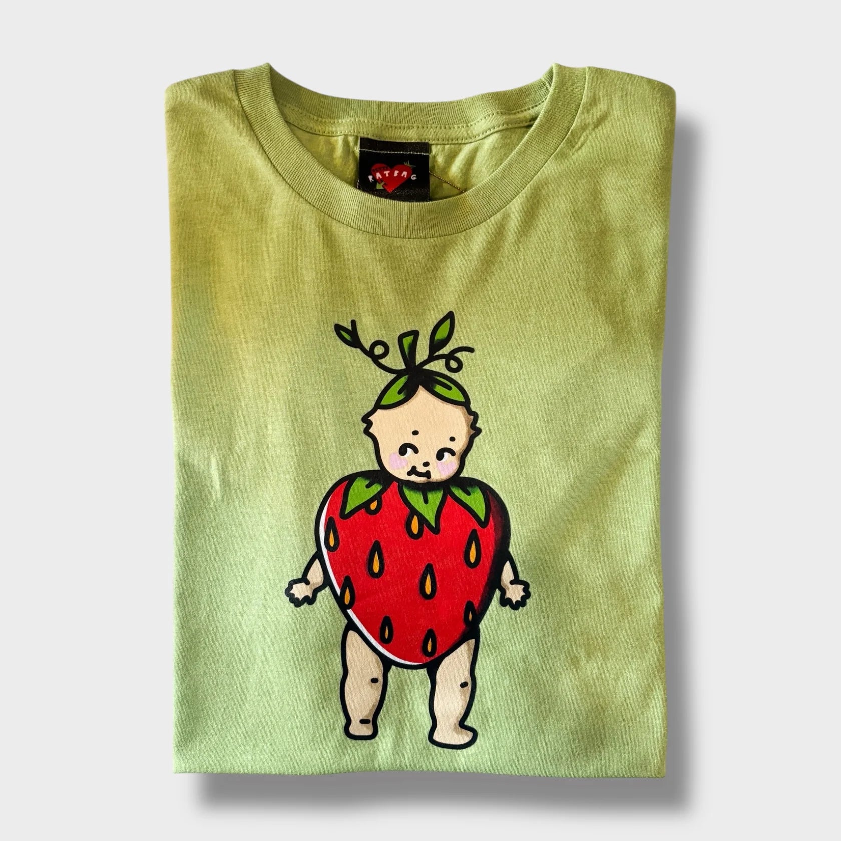 Green t-shirt with a cartoon baby in a strawberry costume on a white background
